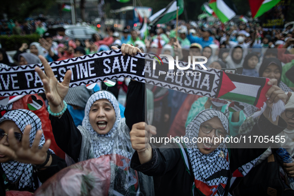 Protesters shout slogans during a rally in solidarity with the Palestinian people outside the US embassy in Jakarta, Indonesia, on October 2...