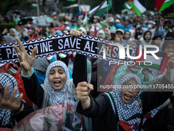 Protesters shout slogans during a rally in solidarity with the Palestinian people outside the US embassy in Jakarta, Indonesia, on October 2...