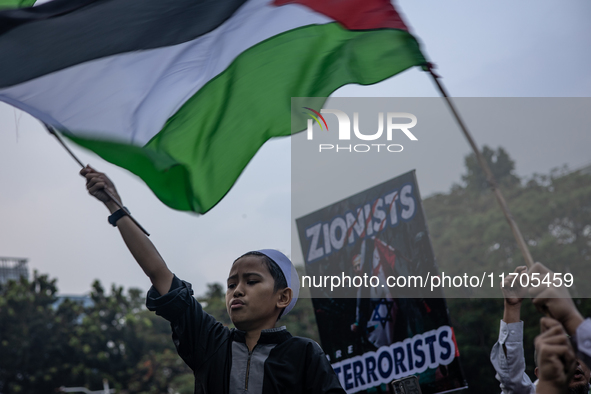 Protesters shout slogans during a rally in solidarity with the Palestinian people outside the US embassy in Jakarta, Indonesia, on October 2...