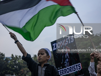 Protesters shout slogans during a rally in solidarity with the Palestinian people outside the US embassy in Jakarta, Indonesia, on October 2...