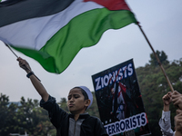 Protesters shout slogans during a rally in solidarity with the Palestinian people outside the US embassy in Jakarta, Indonesia, on October 2...