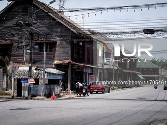 An armed checkpoint is next to an antique wooden house in the city center of Tak Bai. Daily life continues in Tak Bai, Narathiwat, Thailand,...