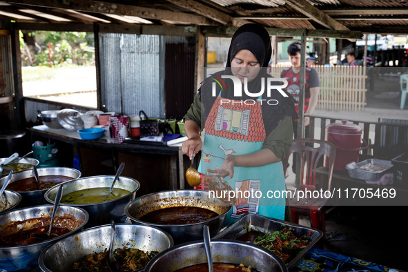 A street food vendor cooks outside a mosque in Tak Bai. Daily life in Tak Bai, Narathiwat, Thailand, on October 25, 2024. Tak Bai is the sit...