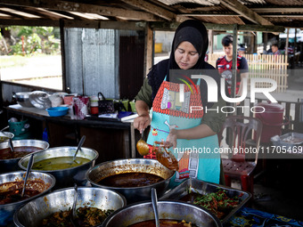 A street food vendor cooks outside a mosque in Tak Bai. Daily life in Tak Bai, Narathiwat, Thailand, on October 25, 2024. Tak Bai is the sit...