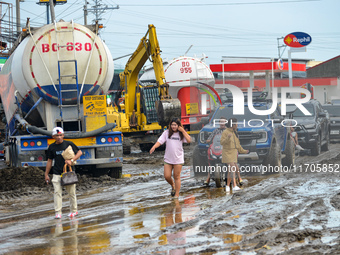 Residents in Lemery, Batangas, were seen cleaning up mud and debris on October 25, 2024, after Tropical Storm Kristine caused severe floodin...