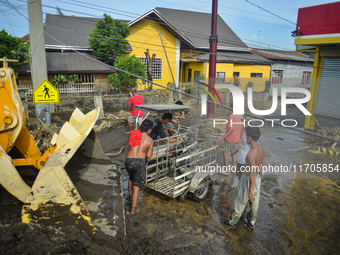 Residents in Lemery, Batangas, were seen cleaning up mud and debris on October 25, 2024, after Tropical Storm Kristine caused severe floodin...