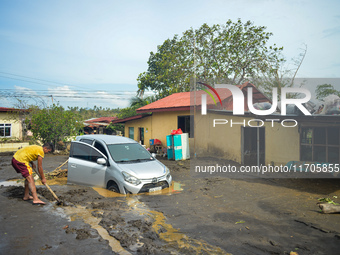 Residents in Lemery, Batangas, were seen cleaning up mud and debris on October 25, 2024, after Tropical Storm Kristine caused severe floodin...