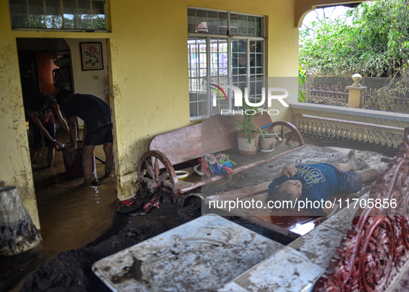 Residents in Lemery, Batangas, were seen cleaning up mud and debris on October 25, 2024, after Tropical Storm Kristine caused severe floodin...