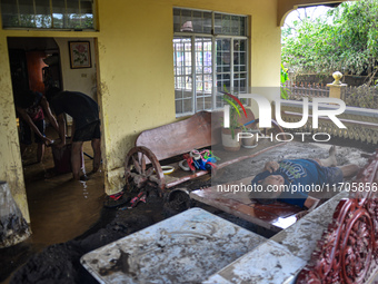 Residents in Lemery, Batangas, were seen cleaning up mud and debris on October 25, 2024, after Tropical Storm Kristine caused severe floodin...