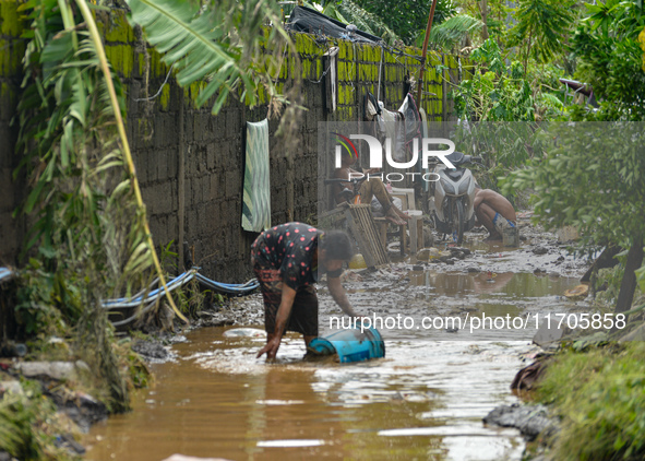 Residents in Lemery, Batangas, were seen cleaning up mud and debris on October 25, 2024, after Tropical Storm Kristine caused severe floodin...