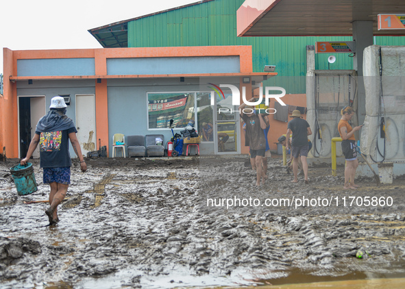 Residents in Lemery, Batangas, were seen cleaning up mud and debris on October 25, 2024, after Tropical Storm Kristine caused severe floodin...