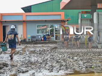 Residents in Lemery, Batangas, were seen cleaning up mud and debris on October 25, 2024, after Tropical Storm Kristine caused severe floodin...