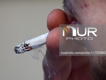 A person smokes a cigarette in Krakow, Poland on October 25, 2024. (