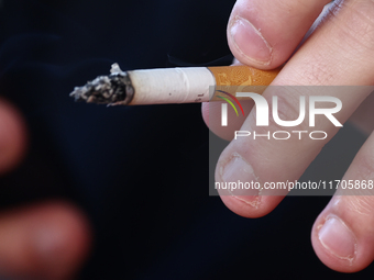 A person smokes a cigarette in Krakow, Poland on October 25, 2024. (