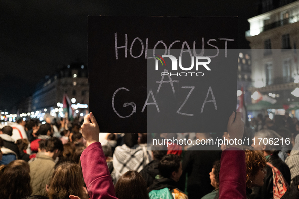 A protester holds a sign reading ''Holocaust in Gaza'' during a demonstration in support of Palestinian and Lebanese people as intense Israe...