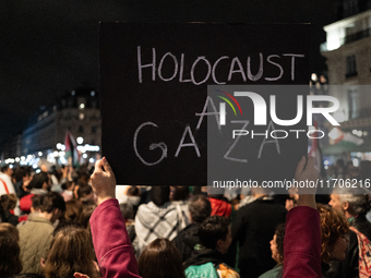 A protester holds a sign reading ''Holocaust in Gaza'' during a demonstration in support of Palestinian and Lebanese people as intense Israe...