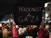 A protester holds a sign reading ''Holocaust in Gaza'' during a demonstration in support of Palestinian and Lebanese people as intense Israe...