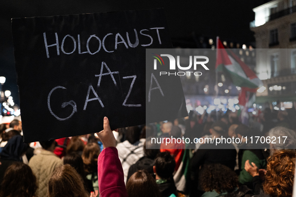 A protester holds a sign reading ''Holocaust in Gaza'' during a demonstration in support of Palestinian and Lebanese people as intense Israe...