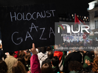 A protester holds a sign reading ''Holocaust in Gaza'' during a demonstration in support of Palestinian and Lebanese people as intense Israe...