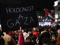 A protester holds a sign reading ''Holocaust in Gaza'' during a demonstration in support of Palestinian and Lebanese people as intense Israe...