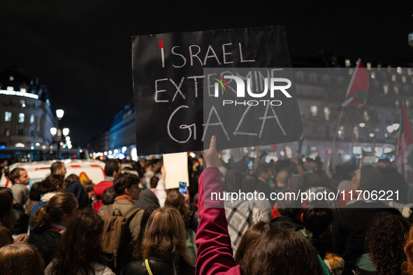 A protester holds a sign reading ''Israel extermine in Gaza'' during a demonstration in support of Palestinian and Lebanese people as intens...