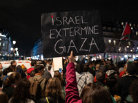 A protester holds a sign reading ''Israel extermine in Gaza'' during a demonstration in support of Palestinian and Lebanese people as intens...