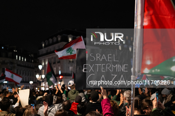 A protester holds a sign reading ''Israel extermine in Gaza'' during a demonstration in support of Palestinian and Lebanese people as intens...