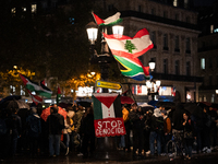 Protesters with flags attend a demonstration in support of Palestinian and Lebanese people as intense Israeli attacks occur in Gaza and Leba...