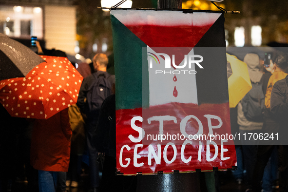 A protester holds a sign reading ''stop genocide'' during a demonstration in support of Palestinian and Lebanese people as intense Israeli a...