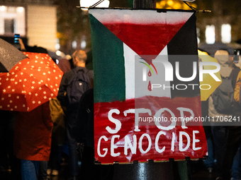 A protester holds a sign reading ''stop genocide'' during a demonstration in support of Palestinian and Lebanese people as intense Israeli a...