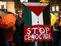 A protester holds a sign reading ''stop genocide'' during a demonstration in support of Palestinian and Lebanese people as intense Israeli a...