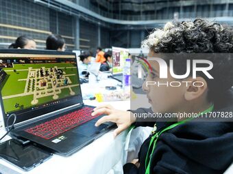 Participants program a robot during the Qingdao International Invitational Tournament of the 2024 Asia-Pacific RoboCup in Qingdao, China, on...