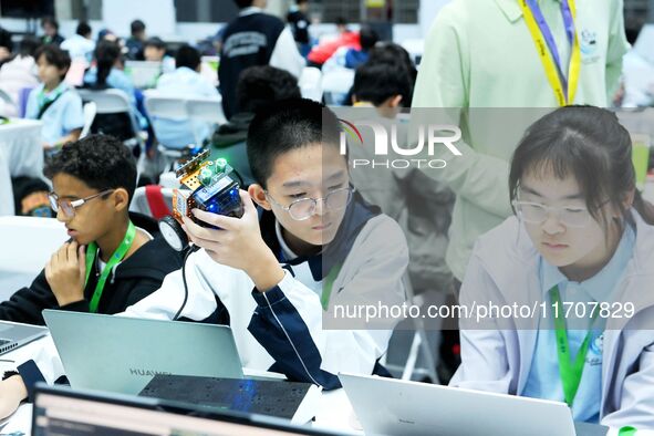 Participants program a robot during the Qingdao International Invitational Tournament of the 2024 Asia-Pacific RoboCup in Qingdao, China, on...