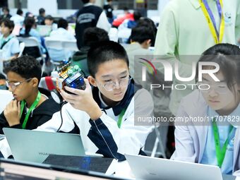 Participants program a robot during the Qingdao International Invitational Tournament of the 2024 Asia-Pacific RoboCup in Qingdao, China, on...