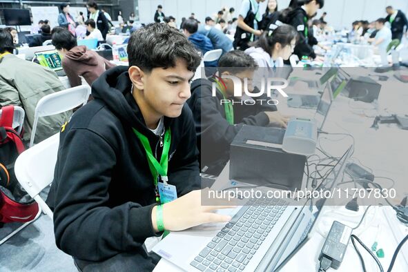 Participants program a robot during the Qingdao International Invitational Tournament of the 2024 Asia-Pacific RoboCup in Qingdao, China, on...