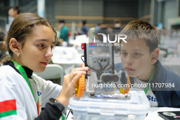 Two foreign players test a robot during the Qingdao International Invitational Tournament of the 2024 Asia-Pacific RoboCup in Qingdao, China...