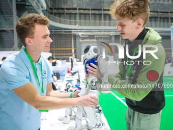 Two foreign players test a robot during the Qingdao International Invitational Tournament of the 2024 Asia-Pacific RoboCup in Qingdao, China...