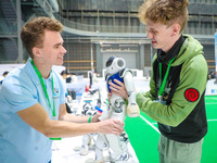 Two foreign players test a robot during the Qingdao International Invitational Tournament of the 2024 Asia-Pacific RoboCup in Qingdao, China...