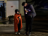 Residents watch as emergency services fight a fire after a Russian drone hits a residential high-rise in Kyiv, Ukraine, on October 25, 2024....