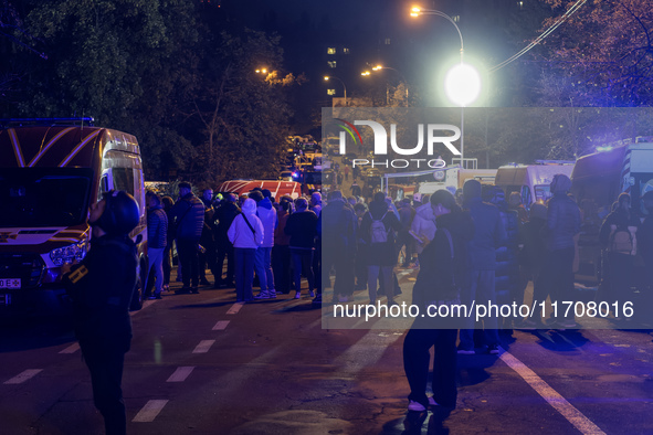 Residents watch as emergency services fight a fire after a Russian drone hits a residential high-rise in Kyiv, Ukraine, on October 25, 2024....