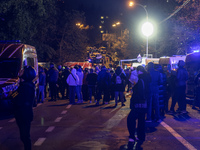 Residents watch as emergency services fight a fire after a Russian drone hits a residential high-rise in Kyiv, Ukraine, on October 25, 2024....