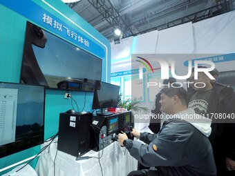 Viewers experience ''simulated flight'' at the 2nd CATA Aviation Conference in Beijing, China, on October 26, 2024. (