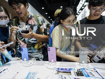 Visitors inspect the Apple iPhone 16 at the Thailand Mobile Expo 2024 in Bangkok, Thailand, on October 26, 2024. The expo showcases the newe...