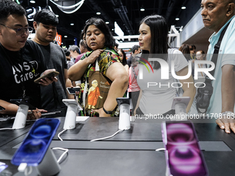 Visitors inspect the Apple iPhone 16 at the Thailand Mobile Expo 2024 in Bangkok, Thailand, on October 26, 2024. The expo showcases the newe...