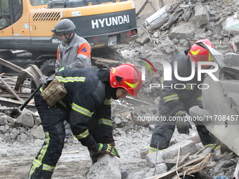 Rescuers work at the scene of an overnight Russian attack in the Novokadatskyi district of Dnipro, Ukraine, on October 25, 2024. NO USE RUSS...