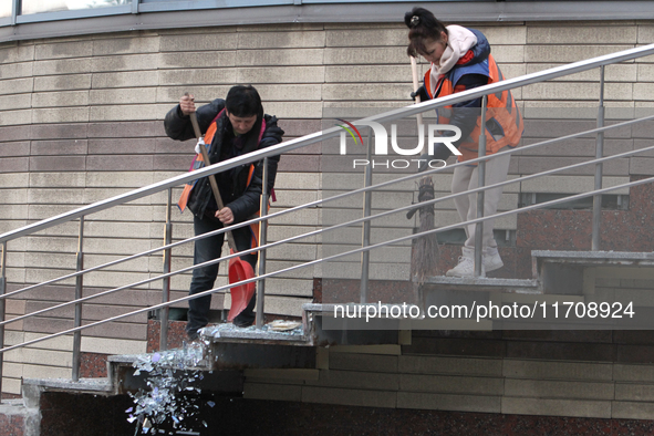 Utility workers sweep away glass shards after a Russian strike on central Dnipro in Dnipro, Ukraine, on October 26, 2024. NO USE RUSSIA. NO...