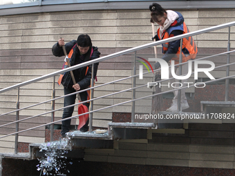 Utility workers sweep away glass shards after a Russian strike on central Dnipro in Dnipro, Ukraine, on October 26, 2024. NO USE RUSSIA. NO...