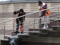 Utility workers sweep away glass shards after a Russian strike on central Dnipro in Dnipro, Ukraine, on October 26, 2024. NO USE RUSSIA. NO...