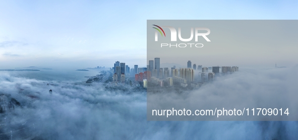 City buildings are seen in the clouds in the West Coast New Area of Qingdao, Shandong province, China, on October 26, 2024. 