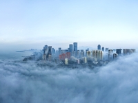 City buildings are seen in the clouds in the West Coast New Area of Qingdao, Shandong province, China, on October 26, 2024. (